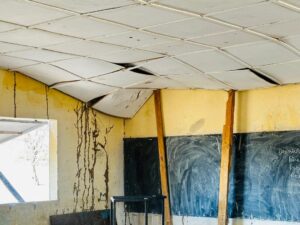 Intérieur d’une salle de classe à Échkar Tagaza montrant un plafond endommagé avec des signes visibles de détérioration.